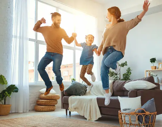 Haus-Familie-Wohnen-Serie-19-23 Glückliche Familie tanzt im Wohnzimmer.
